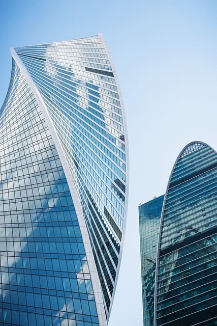 Modern twin glass towers reaching into a blue sky